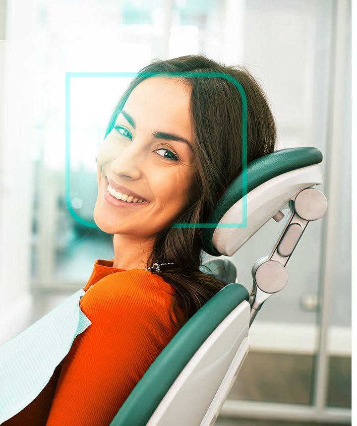 Paciente sorrindo durante atendimento na cadeira odontológica da OdontoVida